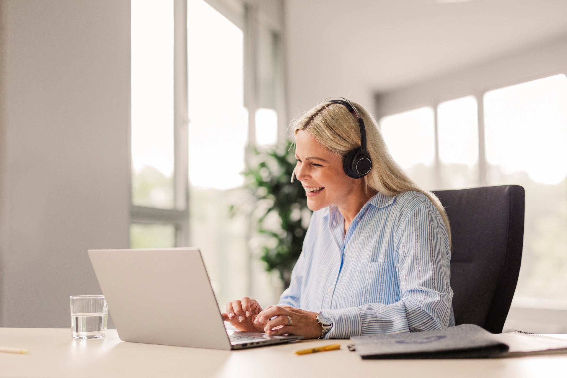 Eine Trusted Shops Mitarbeiterin ist an ihrem Laptop in einem Kundengespräch